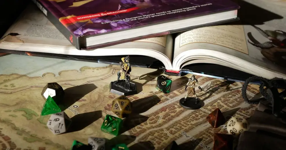 Livro de regras de RPG de mesa aberto sobre mapa com dados e miniaturas